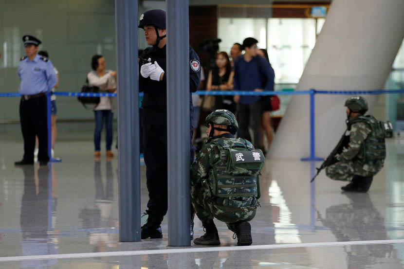 Paramilitary police officers position themselves behind pillars as a bomb disposal team checks suspicious luggage near the explosion site at Shanghai Pudong International Airport, June 12, 2016. Aly Song/Reuters