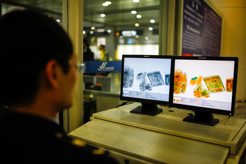 A security officer checks X-ray images of carry-on luggage at Sunan Shuofang International Airport in Wuxi, Jiangsu province, Dec. 22, 2014. Wang Yu/VCG