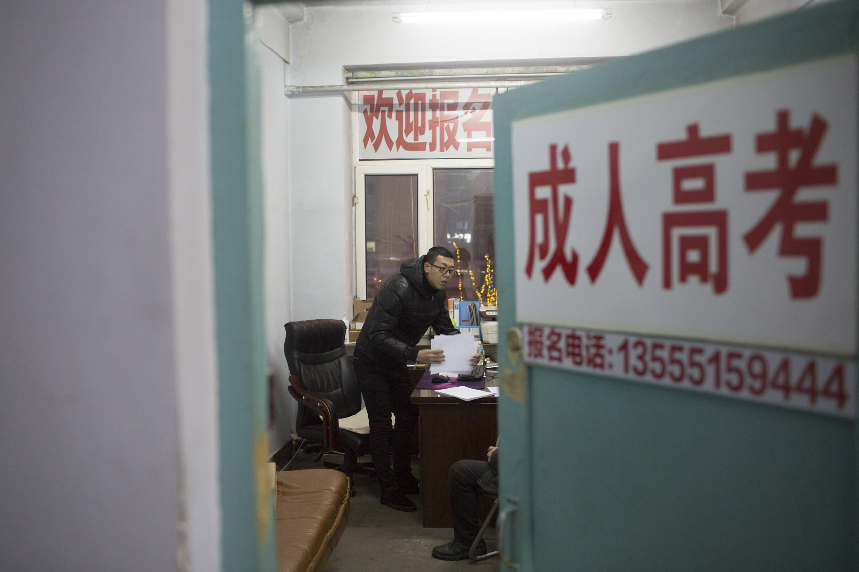 Yang Kun is visited by a client at his adult education recruitment practice in Shuangyashan, Jan. 20, 2016. Yang started the firm following a demotion at the mine where he worked previously. Zhou Pinglang/Sixth Tone