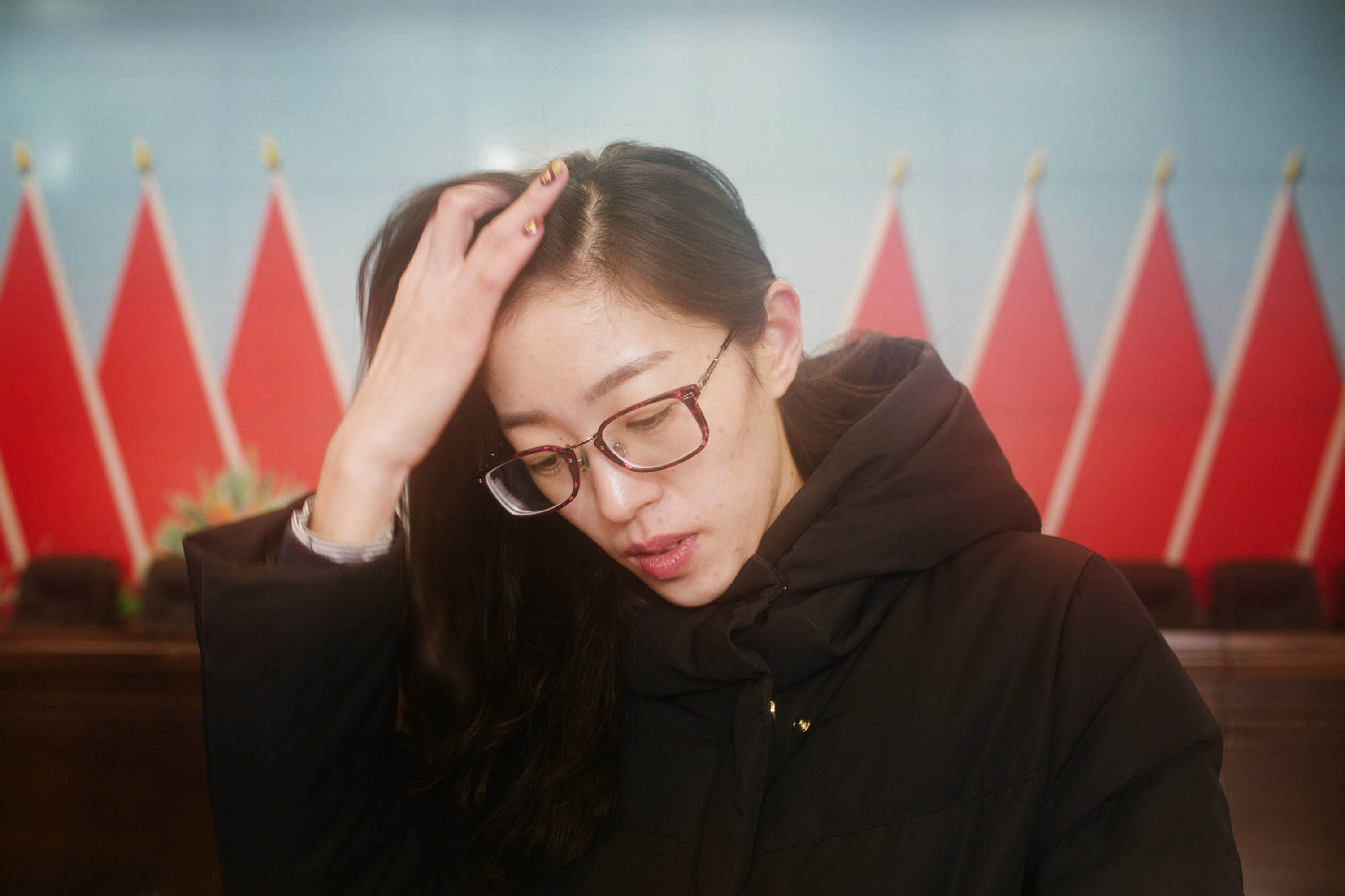 During a conference held to discuss staff restructuring, Ru Dongying waits to sign papers agreeing to the terms of her resignation, Jan. 14 2016. Ru left her job after being told she would have to face internal competition and reapply. Zhou Pinglang/Sixth Tone
