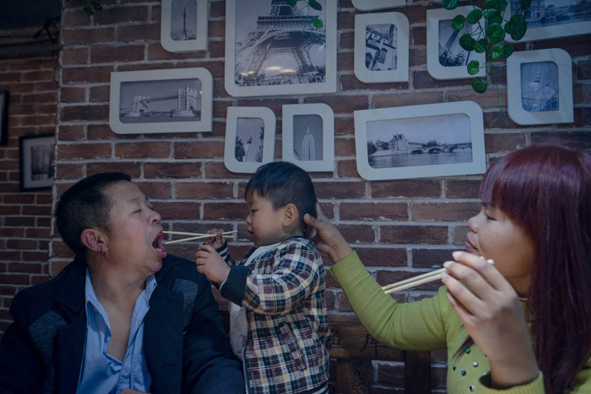 Sophorn and Zhang Chunfa’s son plays with chopsticks in a restaurant, Zhengzhou, Henan province, March 29, 2016. Cong Yan for Sixth Tone