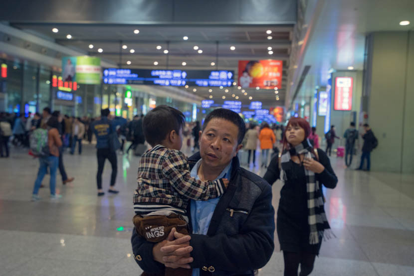 Zhang Chunfa holds his son as Sophorn rushes to catch her flight, Shanghai, March 30, 2016. Cong Yan for Sixth Tone