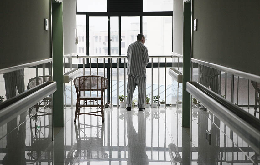 A man stands by a window at the end of the hallway at Putuo District Shiquan Street Community Health Service Center, Shanghai, May 5, 2013. Gao Zheng/Sixth Tone