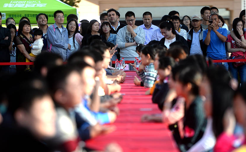 People watch single women and men chatting during a speed dating event in Jinan, Shandong province, Sept. 12, 2015. Wen Lu/VCG