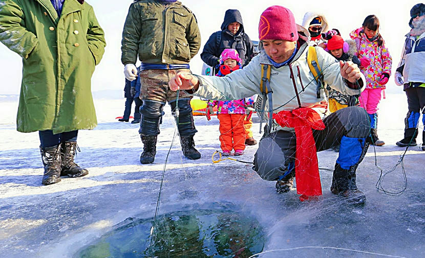 He Junheng teaches his students how to ice fish during Jiabeicun’s winter tour in Mudanjiang, Heilongjiang province, Jan. 17, 2016. Courtesy of Jiabeicun