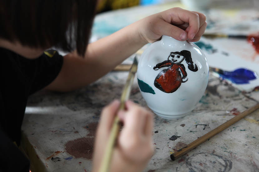 A Jiabeicun student paints a piece of pottery in Jingdezhen, Jiangxi province, July 19, 2016. Andy Boreham/Sixth Tone