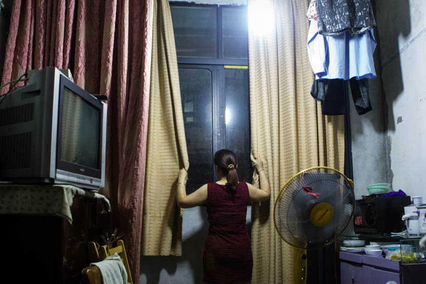 A resident on Yongkang Lu closes the curtains on the crowds beneath. Shanghai, July 16, 2016. Wei Yi/Sixth Tone