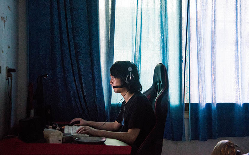 Li Lingzhi plays computer games in his room at home, Hengdong County, Hunan Province, July 5, 2016. Zhou Yinan/Sixth Tone