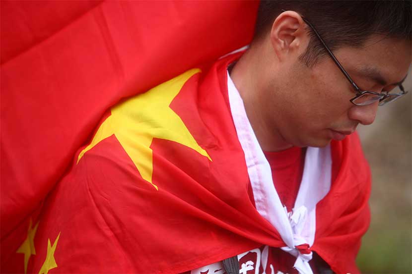 A man wears a Chinese national flag to go see the 2008 Beijing Games Olympic Torch Relay in Hong Kong, May 2, 2008. Protests surrounding the torch relay were a major topic on Anti-CNN. Eric Tsang/VCG