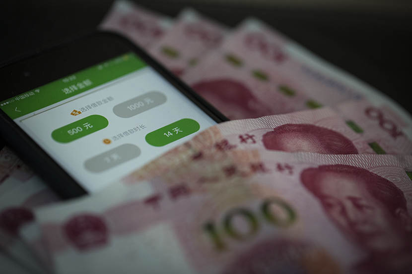 A photo illustration shows the CashBUS app on a cellphone nestled among hundred-yuan banknotes. Yang Shenlai/Sixth Tone