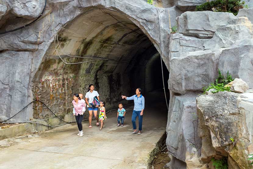 People walk through the tunnel in Mahuai Village, Guizhou province, Aug. 27, 2016. Denise Hruby/Sixth Tone