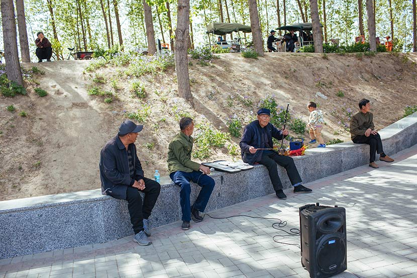 Local residents sit in a park near Baiyang Lake in Anxin County, Hebei province, April 11, 2017. Wu Huiyuan/Sixth Tone