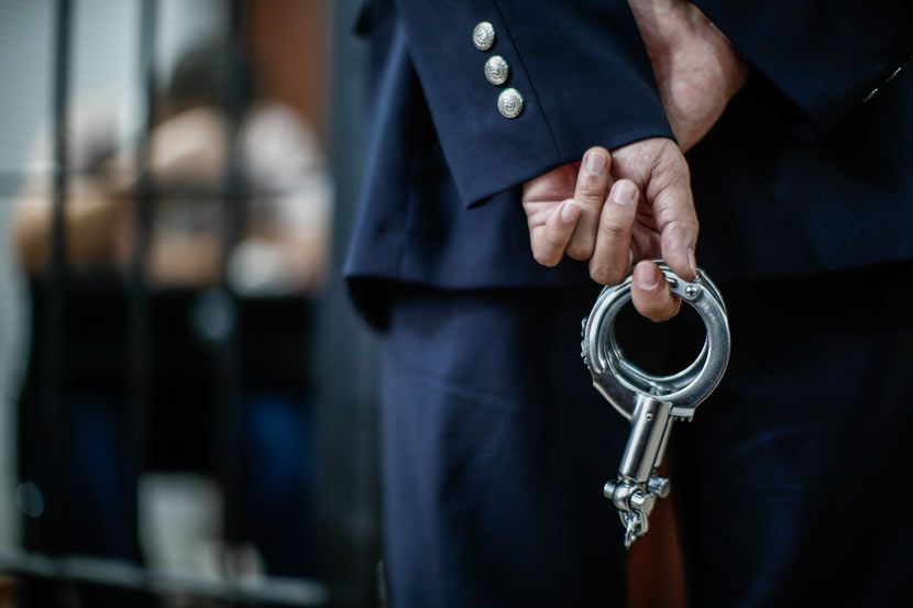A policeman holds a pair of handcuffs in Shanghai, Nov. 28, 2014. Yang Yi/Sixth Tone