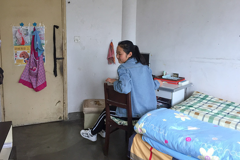 Li Xiumao sits in her bedroom at her elevator company’s employee housing unit in Shanghai, April 7, 2017. Fu Danni/Sixth Tone