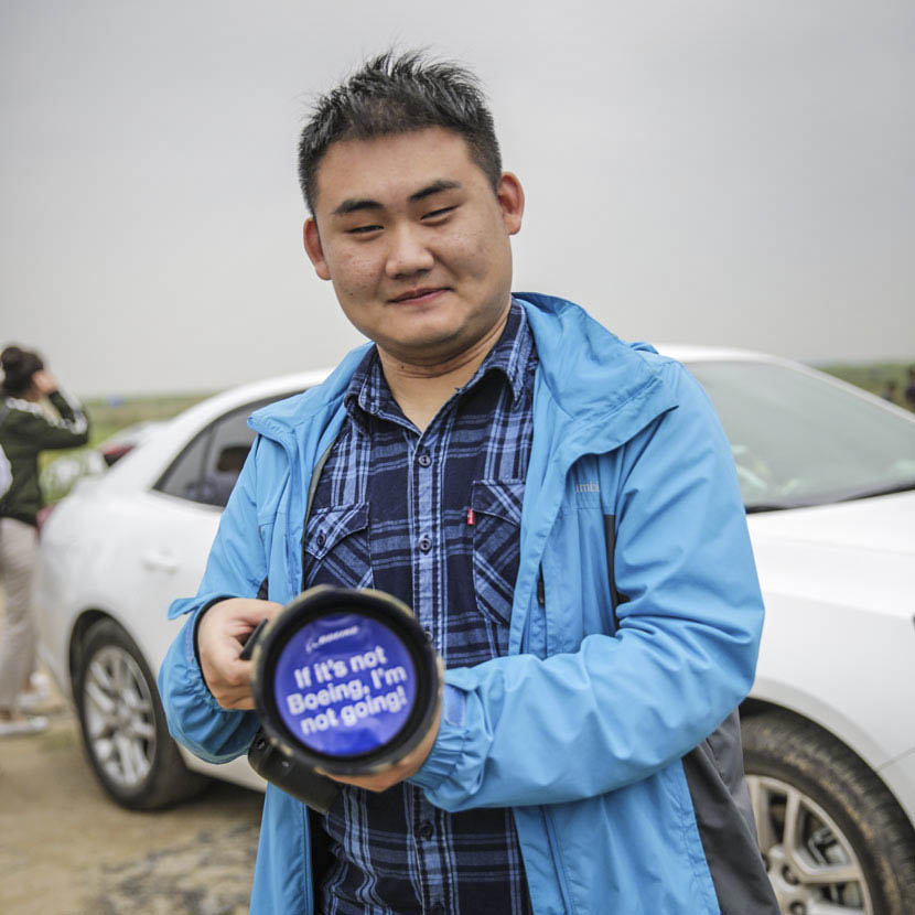 Sun Shengdi, who works in the finance industry, displays his lens cap outside Shanghai’s Pudong International Airport, May 5, 2017. Daniel Holmes/Sixth Tone