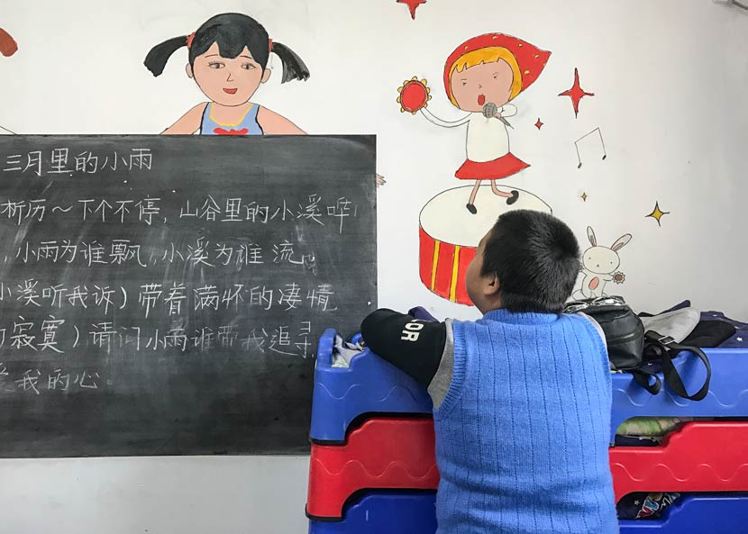 A student looks at the blackboard in a classroom at the Lingxing Community Service Center in Taiyuan, Shanxi province, April 5, 2017. Wang Yiwei/Sixth Tone
