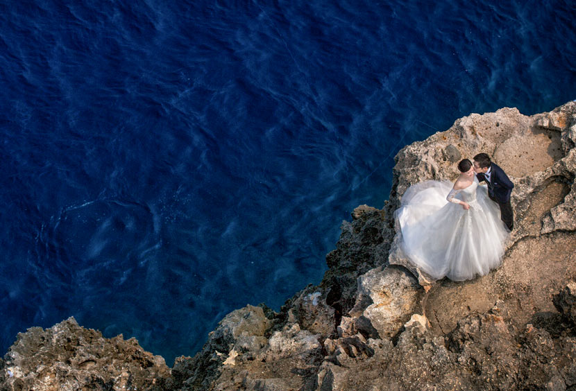 A couple poses for a wedding photo on a seaside cliff in Okinawa, Japan, April 3, 2016. Courtesy of Guo Kun