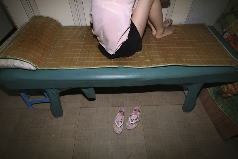 A sex worker sits on her bed in Hangzhou, Zhejiang province, Sept. 17, 2010. Li Qin/VCG