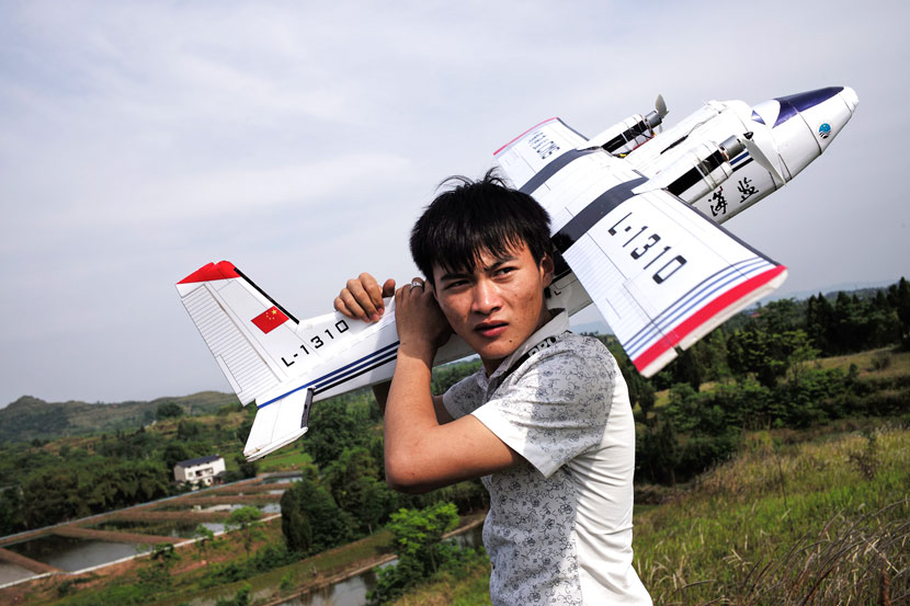 Hu Bo carries his model Y-12 aircraft after taking it out for a flight in Dazu County, Chongqing, May 16, 2017. Wu Yue/Sixth Tone