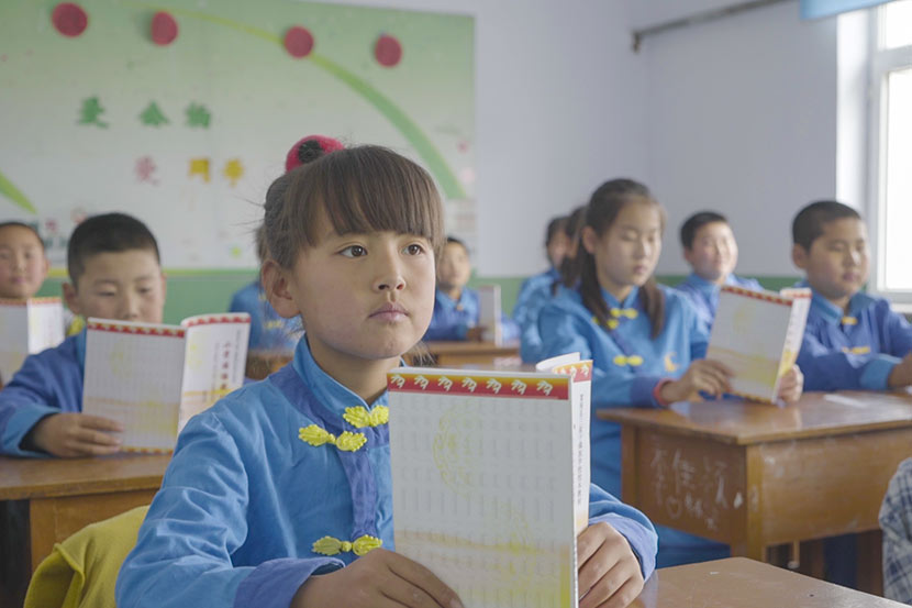 Students read from textbooks during a Manchu class at Sanjiazi Manchu Elementary School in Sanjiazi Village, Qiqihar, Heilongjiang province, May 10, 2017. Tang Xiaolan/Sixth Tone