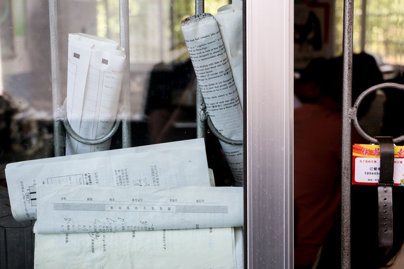 Rolled-up exam papers are displayed in the bars of a school window in Guanzhuang Township, Hunan province, May 17, 2017. Cai Yiwen/Sixth Tone
