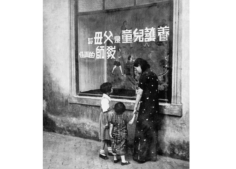 A woman and two girls gaze at a slogan in the window of a Popular Education Center in Zhenjiang, Jiangsu province, 1936. Courtesy of ‘Old Photos’