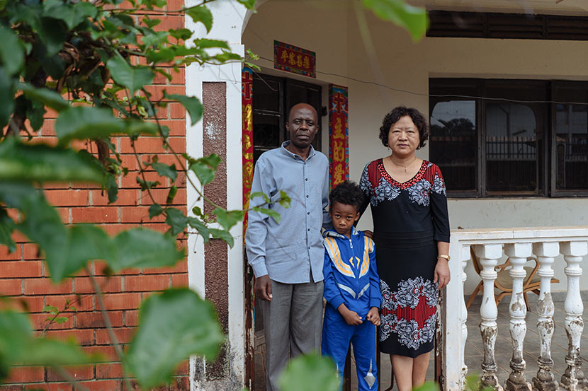 Elly Amani Gamukama (left), Yuan Zhongshun, and their son pose for a photo in front of their house in Entebbe, Uganda, March 24, 2018. Hannah Reyes Morales for Sixth Tone