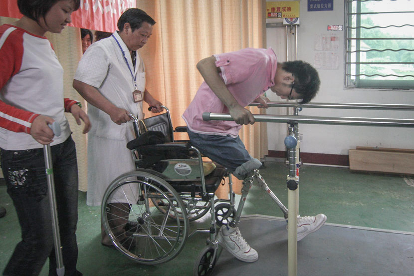 Zheng Haiyang attempts to stand on prosthetic legs during rehabilitation in Mianyang, Sichuan province, May 8, 2009. Guo Guoquan/IC