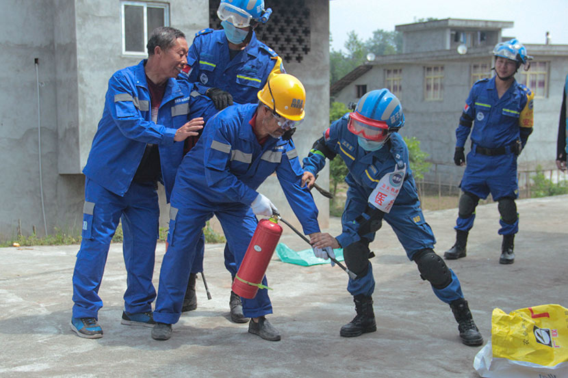 A member of Blue Sky Rescue teaches a villager to use a fire extinguisher in Baishu Village, Sichuan province, April 29, 2018. Lin Qiqing/Sixth Tone