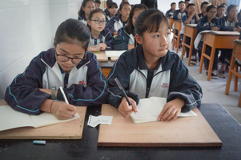 Students take notes during a career-sharing event at Nanjian No. 2 Middle School in Nanjian Yi Autonomous County, Yunnan province, March 22, 2018. Fan Yiying/Sixth Tone