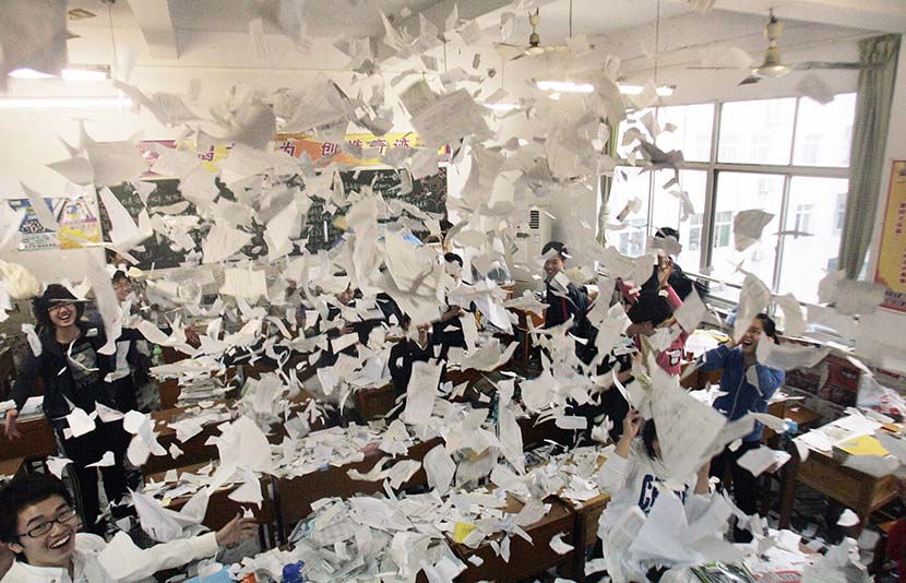 Students throw their study materials into the air after completing their college entrance exams in Xiangyang, Hubei province, June 8, 2010. Li Xi/VCG