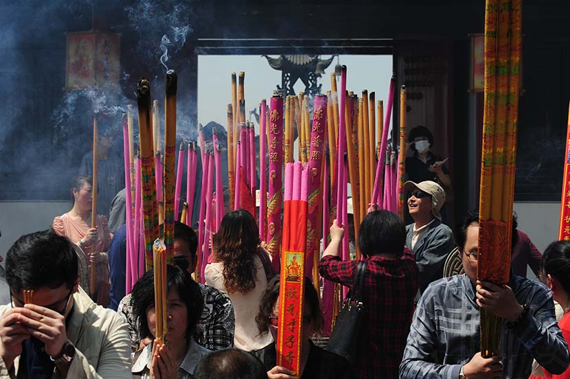 Parents pray and burn incense to bring their children good luck on the college entrance exams in Nantong, Jiangsu province, May 13, 2013. Chen Feng/VCG
