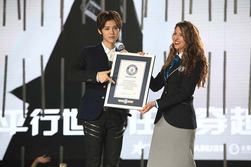 Lu Han (left) receives the Guinness World Record award for most comments on a social media post in Beijing, Sept. 25, 2015. VCG