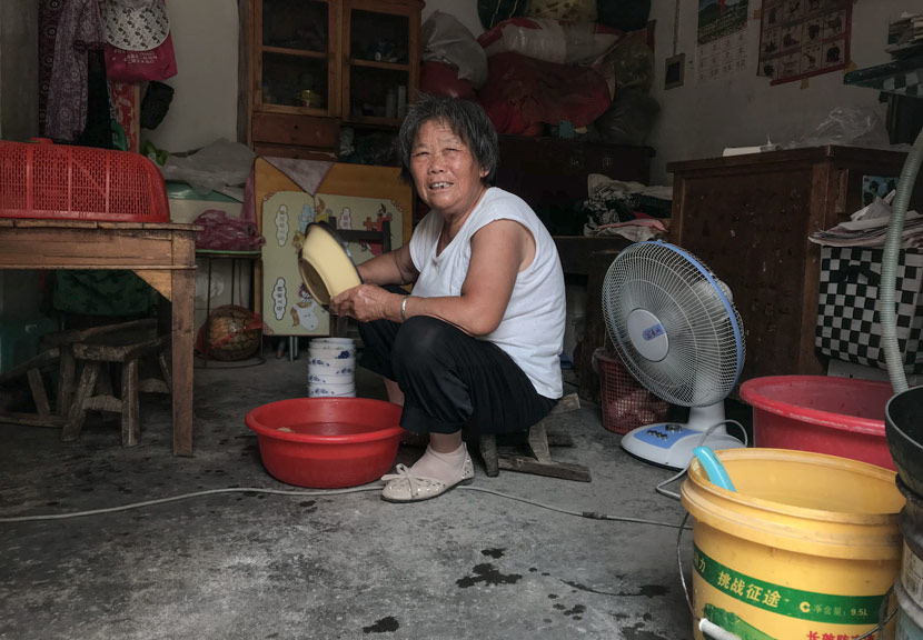 Zhao Meixia, 77, washes dishes at her home in Si County, Anhui province, June 8, 2018. Tang Xiaolan/Sixth Tone