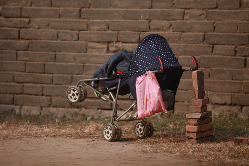 A child sleeps in a tilted stroller, Xi’an, Shaanxi province, Jan. 10, 2013. Wang Jing/Chinese Business View/VCG