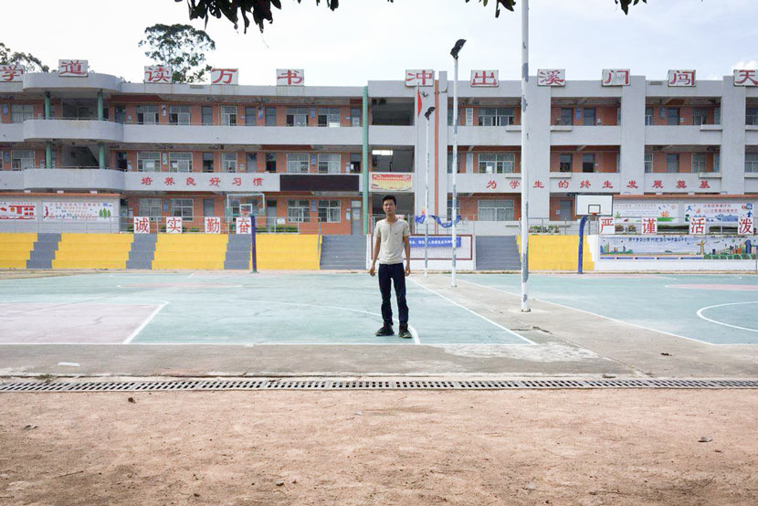 Liang Chaowei poses in front of his former school in Tangxi, Guangdong province, May 25, 2018. Courtesy of Liang Chaowei