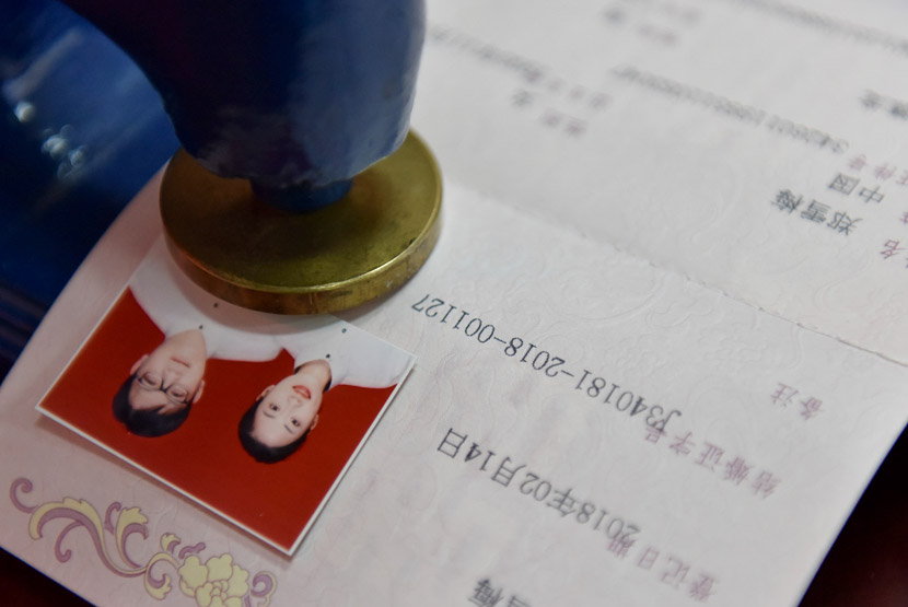 An official stamps a marriage certificate at a civil affairs bureau in Chaohu, Anhui province, Feb. 14, 2018. Ma Fengcheng/VCG