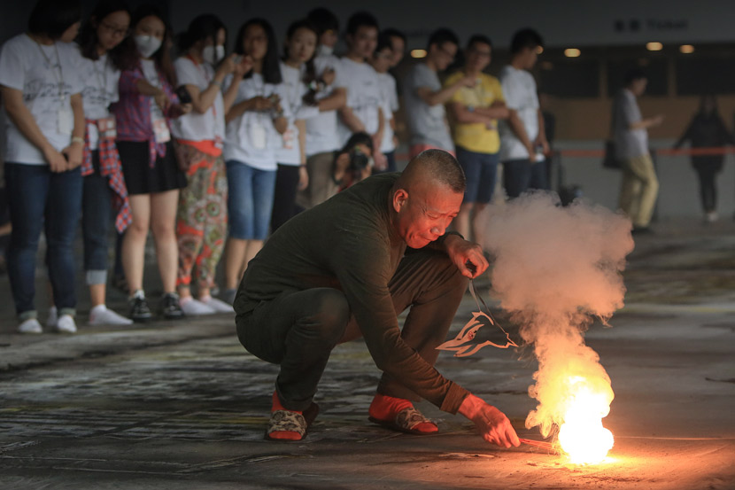 Cai Guoqiang (front) prepares his work ‘The Bund Without Us,’ at the Power Station of Art in Shanghai, July 24, 2014. Wang Rongjiang/VCG