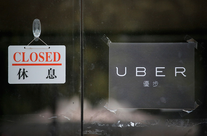 A closed sign on the front door of Uber’s Hong Kong office, Aug. 12, 2015. Vincent Yu/IC