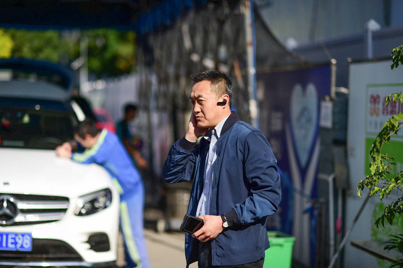 Cao Jun takes a phone call at Xihaner Car Wash in Shenzhen, Guangdong province, April 25, 2018. Liao Jian/VCG