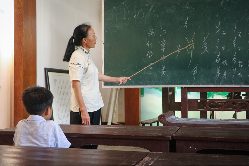 Hu Meiyue, ‘nüshu’ inheritor and guide, teaches visitors at Nüshu Museum in Jiangyong County, Hunan province, July 18, 2018. Yin Yijun/Sixth Tone