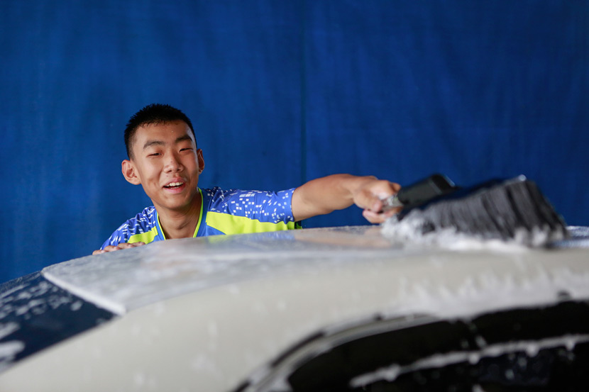 An employee washes a car at Xihaner in Shenzhen, Guangdong province, April 25, 2018. Liao Jian/VCG