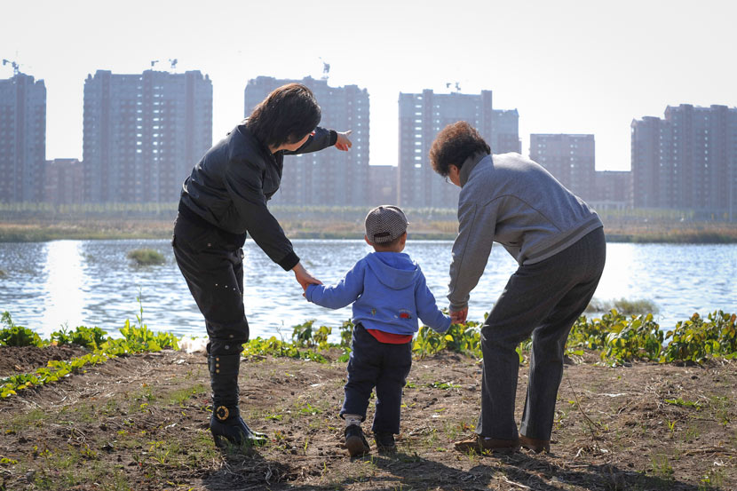 A mother points out new apartment buildings while taking her child out for a walk in Changchun, Jilin province, 2010. Zhang Xiyu/IC