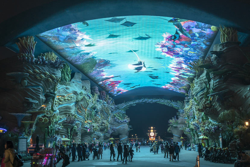 Visitors pass underneath an aquarium tank at the Chimelong Ocean Kingdom theme park in Zhuhai, Guangdong province, Jan. 26, 2018. Wang Gang/VCG