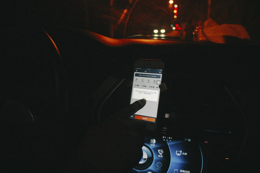 Inside his car, Peng points out the notification in Didi Chuxing’s app announcing the decision to suspend its nighttime services, in Shanghai, Sept. 10, 2018. Xue Yujie/Sixth Tone