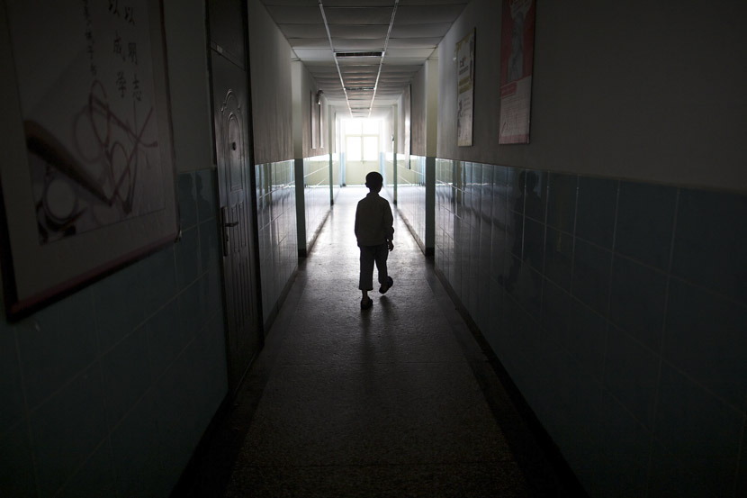 A boy meanders down the hallway of a school in Beijing, May 31, 2012. Zhou Gangfeng/Beijing News/VCG