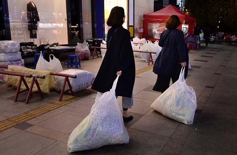 Two Chinese ‘daigou’ drag bags through Dongdaemun Market in Seoul, South Korea, Nov. 14, 2016. VCG