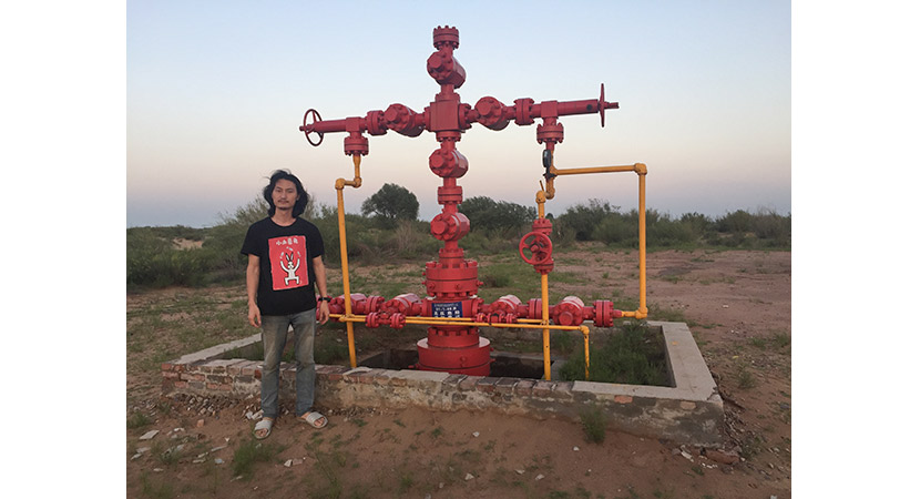 The artist Brother Nut poses for a photo near a gas well in Xiaohaotu Township, Shaanxi province, July 2018. Courtesy of Brother Nut