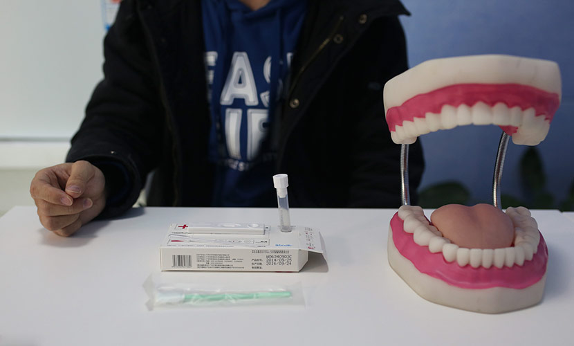 A volunteer demonstrates an HIV testing kit at the office of Blued-affiliated nonprofit organization Danlan in Beijing, Nov. 24, 2016. Liu Chang/VCG