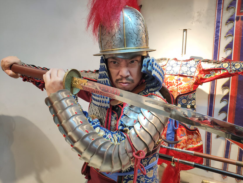 Liu Shiwei strikes a fierce pose at an underground armor store in Shanghai, Dec. 10, 2018. Kenrick Davis/Sixth Tone